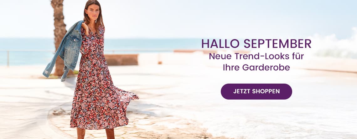 HALLO SEPTEMBER – Neue Trend-Looks für Ihre Garderobe – Frau in rotem Blumenkleid und Jeansjacke am Strand