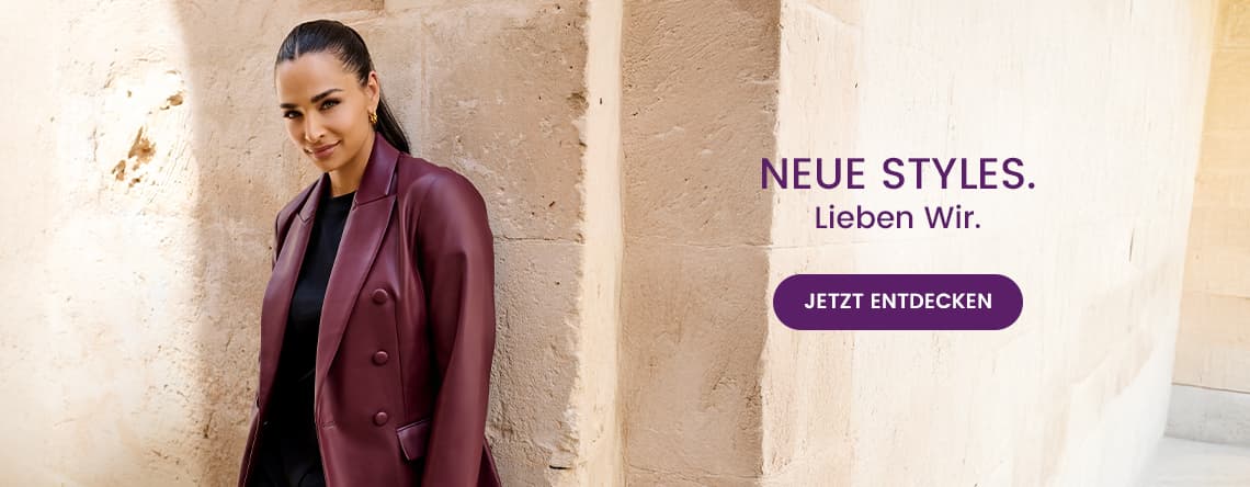 Neue Styles. Lieben Wir. Jetzt entdecken – Frau im weinroten Blazer steht vor einer Wand.