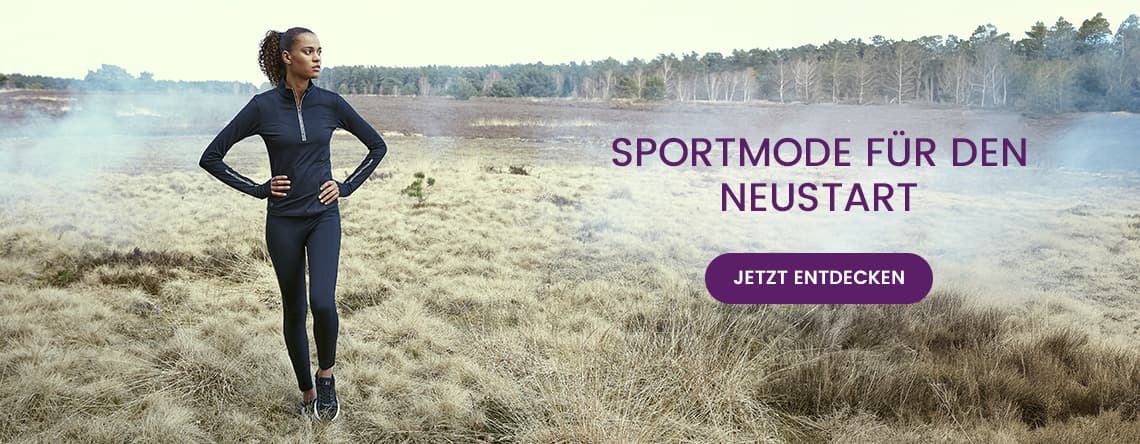 Sportmode für den Neustart – Frau in schwarzer Sportkleidung steht in einer Landschaft, Hände in die Hüften gestützt