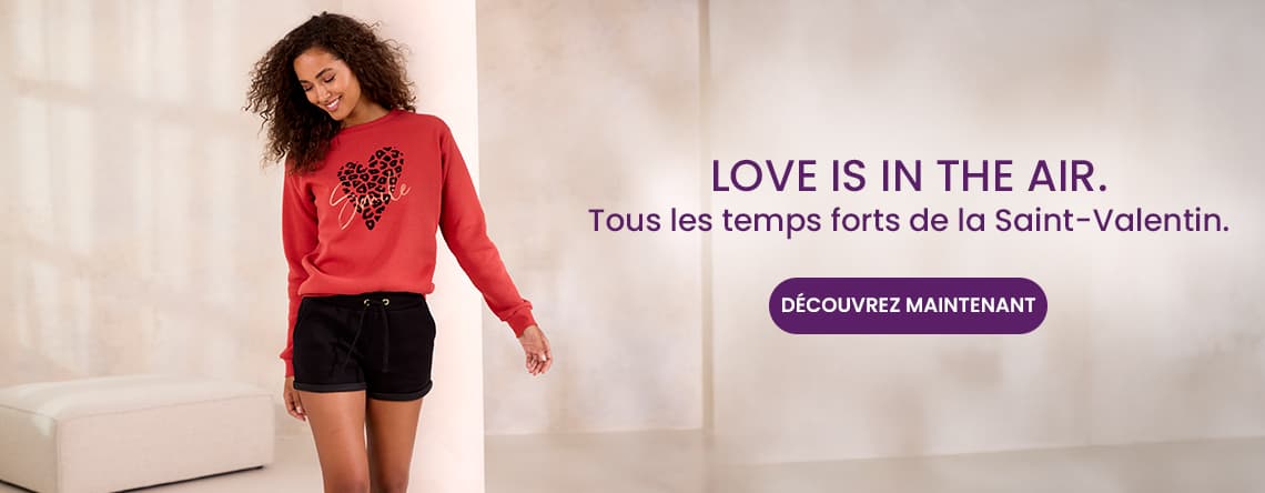 Love is in the air - Tous les temps forts de la Saint-Valentin. Femme en pull rouge avec motif cœur léopard et short noir.