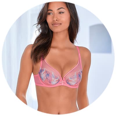 Femme en soutien-gorge rose avec motifs floraux, face à l'objectif