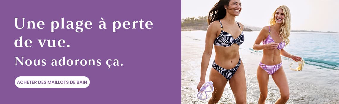 Une plage à perte de vue. Nous adorons ça. Deux femmes en maillot de bain marchant sur la plage. Acheter des maillots de bain.