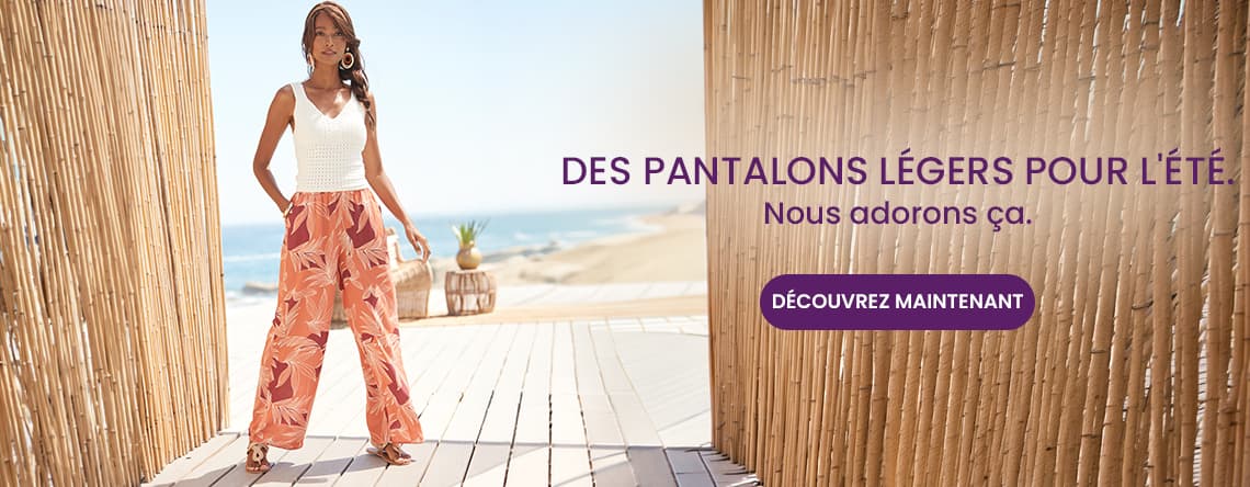 Des pantalons légers pour l’été – Personne debout en pantalon large imprimé et débardeur blanc sur terrasse face à la mer