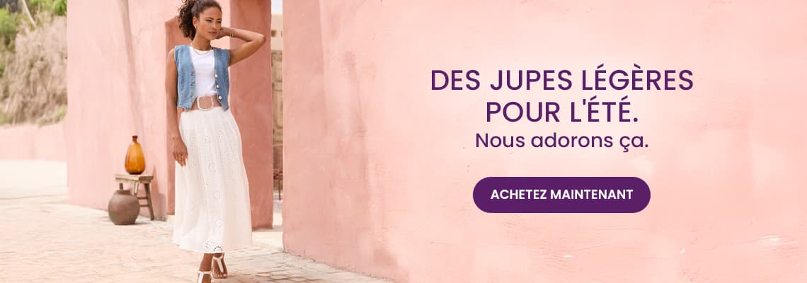 Des jupes légères pour l’été – Personne debout en jupe longue blanche et gilet en jean devant un mur rose